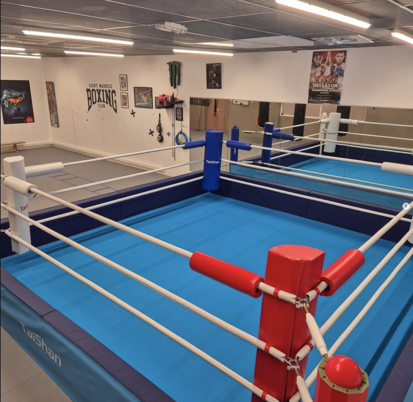 Le ring du Boxing Club Saint-Maurice vu en plongée, avec le logo du club peint sur le mur